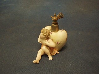 A 19th Century German biscuit porcelain perfume atomiser in the form of a seated cherub with heart shaped haversack (wing f), 6"
