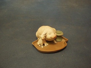A 19th Century German biscuit porcelain match striker in the form of a seated pig and piglet by a top hat, the base impressed 4791 (chip to top hat) 4"