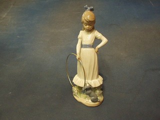 A Nao figure of a standing girl with gilt metal hoop, base marked B17M 10"