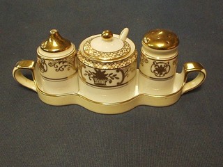 A Noritake gilt 3 piece condiment set comprising mustard pot, salt and pepper, raised on a twin handled tray