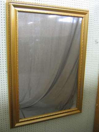 A rectangular plate mirror contained in a decorative gilt frame 42" x 31"