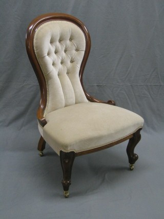 A Victorian mahogany show frame spoon back nursing chair upholstered in white buttoned back material, raised on cabriole supports