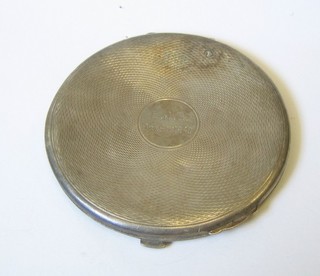 A lady's silver compact with engine turned decoration (dents)
