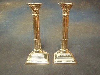 A pair of silver Corinthian column candlesticks with reeded columns raised on stepped bases, the base with Hebrew inscription, London 1967, 18 ozs