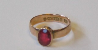 A lady's 9ct gold dress ring set an oval cut red stone