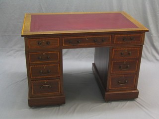 An Edwardian inlaid mahogany kneehole pedestal desk with crossbanded top and red inset tooled leather writing surface above 9 drawers, 42"