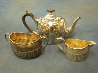 An oval silver plated bachelor's tea service with demi-reeded decoration comprising teapot, twin handled sugar bowl and cream jug by Elkingtons