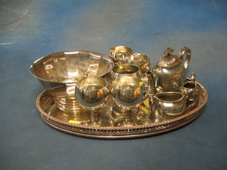 A circular silver plated pedestal bowl 7", 2 decanter labels, 5 silver plated goblets, a 3 piece silver plated tea service and an oval galleried tray