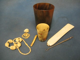 2 horn beakers, a string of ivory beads, 2 pierced ivory pendants, an ivory shoe horn, a folding pocket knife with ivory grip
