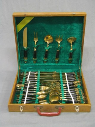 A canteen of gilt metal Thai cutlery contained in a teak canteen box