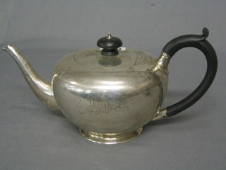 A silver circular teapot with ebony  handle raised on spreading foot, engraved initials, London 1918 by the Goldsmiths & Silversmiths Co. 22 ozs