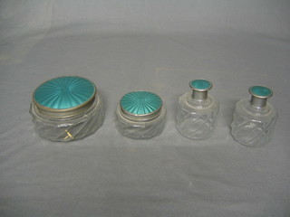 A moulded glass 4 piece dressing table set comprising 4 dressing table jars with simulated enamel finished tops