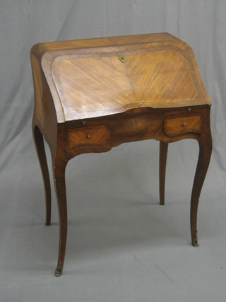 A 20th Century French Kingwood and crossbanded bonheur du jour of serpentine outline (crack to left hand corner of carcus) having a well fitted interior with well, raised on cabriole supports, 27" (some veneer missing)
