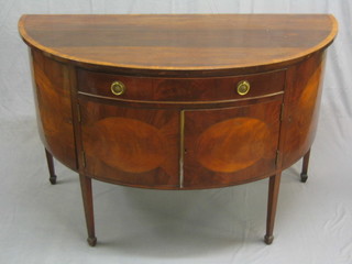 A 19th Century mahogany demi-lune sideboard fitted a drawer above cupboards flanked by a pair of cupboards, raised on square tapering supports ending in spade feet 55" (missing escutcheons)
