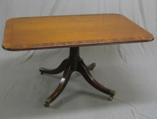 A rectangular Georgian mahogany snap top breakfast table, the crossbanded top inlaid ebony stringing, raised on gun barrel and tripod base ending in brass caps and castors 57", complete with original bolts, (some light chipping to edge)