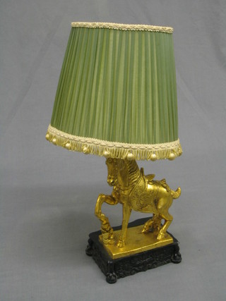 A decorative resin table lamp in the form of a standing gilt painted Tan horse, raised on a hardwood base, 12"