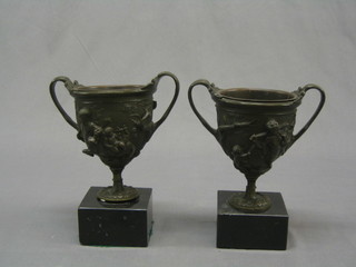 A pair of fine quality 19th Century bronze twin handled urns, decorated mythical beasts raised on square bases 8"