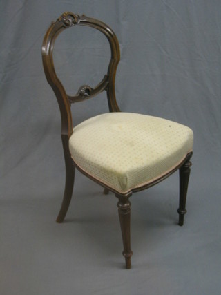 A Victorian carved walnut balloon back chair with shaped mid rail and upholstered seat, raised on turned and fluted supports