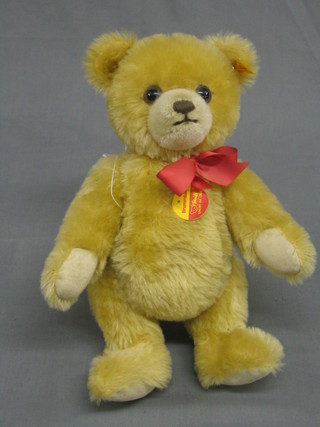 A modern yellow Steiff bear with articulated body and squeaker