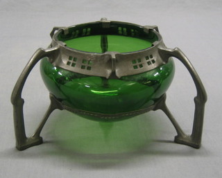An Art Nouveau WMF style circular green glass bowl contained within a pierced circular pewter mount raised on 3 scrolled supports 10"