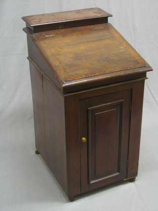 A Victorian mahogany enclosed washstand in the form of  a Davenport desk, the stationery box forming the cistern and the fall front fitted a spigot, enclosed by a panelled door the front (crack to fall front) 19"