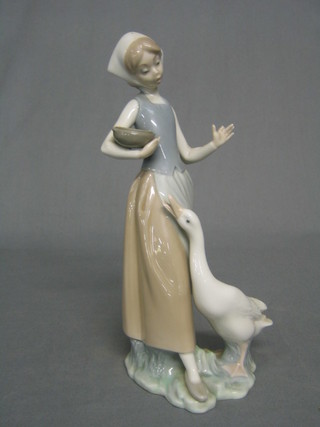 A Lladro figure of a standing girl feeding geese (1 finger f) 9"