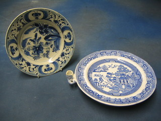 A 19th Century blue and white Willow pattern plate warmer (chip to rim) and an 18th Century plate 10" (2)