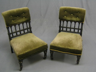 A pair of Victorian ebonised nursing chairs with bobbin turned decoration, having upholstered seats and backs and raised on turned supports