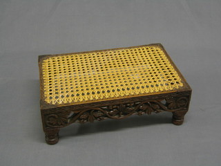 A Victorian pierced and carved oak rectangular footstool with woven cane seat 15"