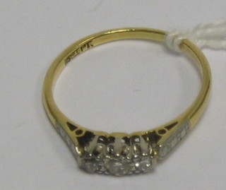 A lady's 18ct gold dress ring with 3 illusion set diamonds and diamonds to the shoulders