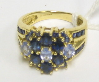A lady's modern gold dress ring set sapphires and small diamonds