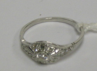 A lady's white gold dress ring set a circular cut diamond supported by 2 baguette cut diamonds and other diamonds