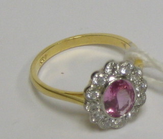 A lady's attractive 18ct gold dress ring set an oval cut pink sapphire surrounded by 12 diamonds (approx 0.60/1.57ct)