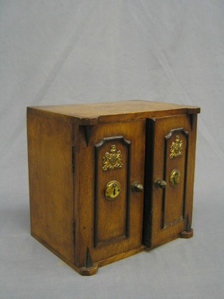 A Victorian honey oak smoker's cabinet in the form of a  Chub double door safe 10"