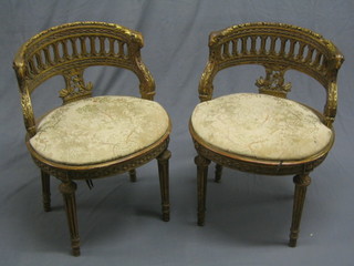 A handsome pair of 19th Century French gilt tub back salon chairs with pierced backs and rams head arm rests, woven cane seats, raised on turned and fluted supports