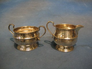 A plain silver twin handled sugar bowl and matching cream jug, London 1932 9 ozs