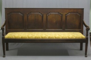 A 19th Century oak settle with panelled back and upholstered seat, raised on club supports 78"