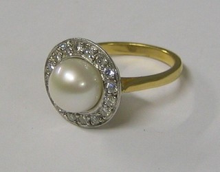 A lady's gold dress ring set a large pearl supported by numerous diamonds (approx 0.40ct)