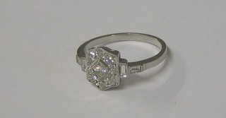 An 18ct white gold Art Deco style dress ring set a diamond to the centre and supported by 9 diamonds and with 4 baguette cut diamonds to the shoulders