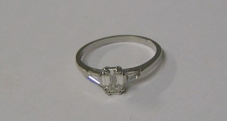 A lady's white gold engagement/dress ring set a rectangular cut diamond the shoulders set 2 baguette cut diamonds