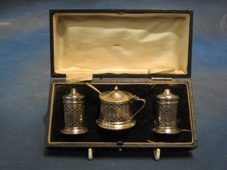 An Art Deco 3 piece pierced silver condiment set comprising mustard pot, pepper pot and salt, Chester 1931, cased
