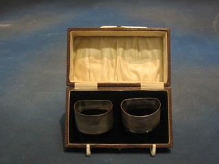 A pair of silver napkin rings with engine turned decoration, Birmingham 1928, cased