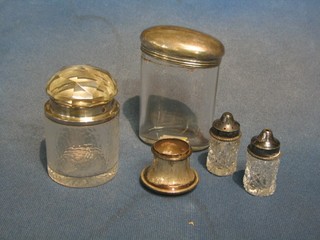 An oval dressing table jar with silver lid 3", a circular silver salts bottle with silver lid 3", a hobnail cut salt and pepper with plated mounts and a silver bottle top
