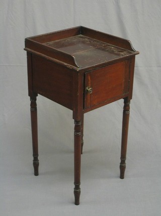 A Victorian mahogany pot cupboard with three-quarter gallery enclosed by a cupboard, raised on turned supports 16"