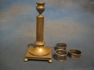 A reeded silver plated candlestick and 3 silver plated napkin rings