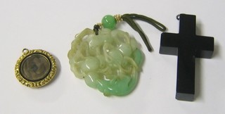 A jade coloured pendant, a black cross and a gilt metal locket