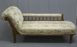A Victorian carved oak show frame chaise longue upholstered in floral buttoned material, raised on turned supports 69"