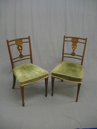 A pair of Edwardian inlaid rosewood slat back dining chairs, the slats inlaid musical trophies, raised on square tapering supports ending in spade feet