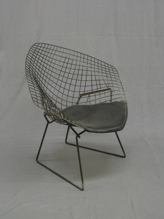 A wire framed designer chair with padded seat by Harry Bertoia