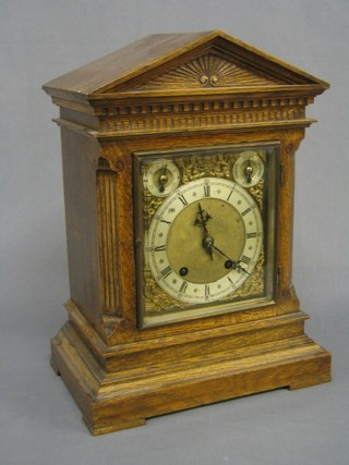 An Edwardian 8 day striking bracket clock with gilt dial, silvered chapter ring and Roman numerals, contained in a carved oak case complete with matching bracket